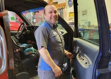 Tim Wells beside a truck in the service bays
